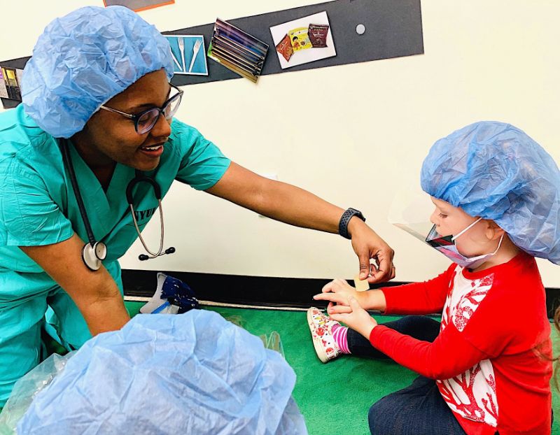 Dr. Whitehead helping child put on a bandaid